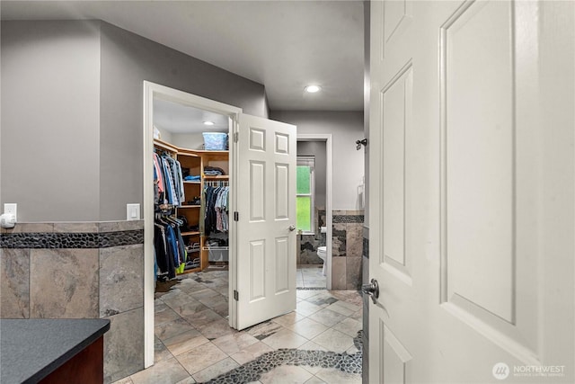 6753 Forest Ridge Dr, Wenatchee, WA 98801 - bathroom featuring toilet, tile walls, a wainscoted wall, a spacious closet, and vanity