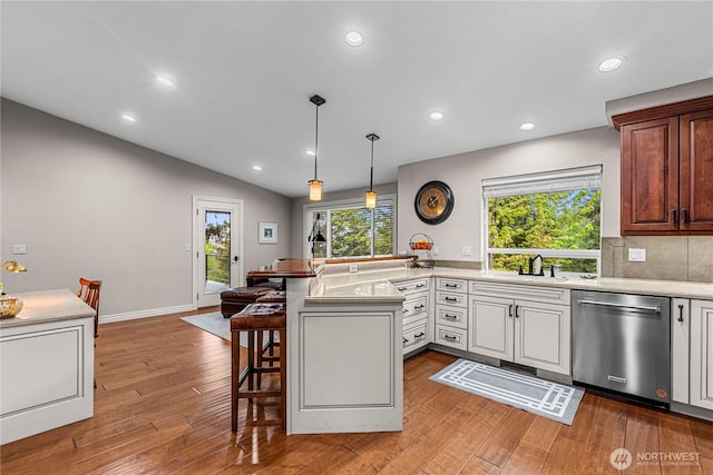 6753 Forest Ridge Dr, Wenatchee, WA 98801 - kitchen with dishwasher, a peninsula, a sink, a kitchen bar, and light countertops