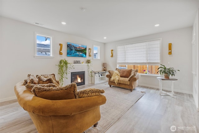 18230 134th Ave E, Puyallup, WA 98374 - living area with a glass covered fireplace, light wood-type flooring, healthy amount of natural light, and recessed lighting