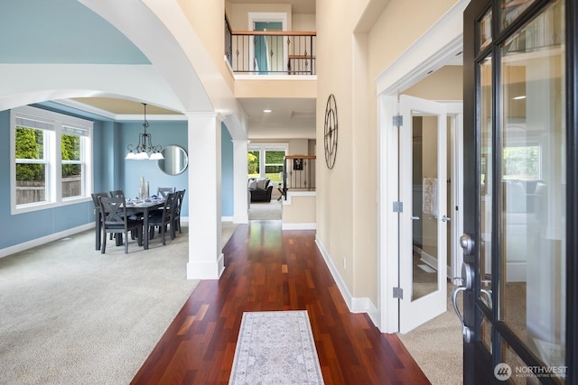 21515 26th St E, Lake Tapps, WA 98391 - foyer entrance with arched walkways, a chandelier, baseboards, and wood finished floors