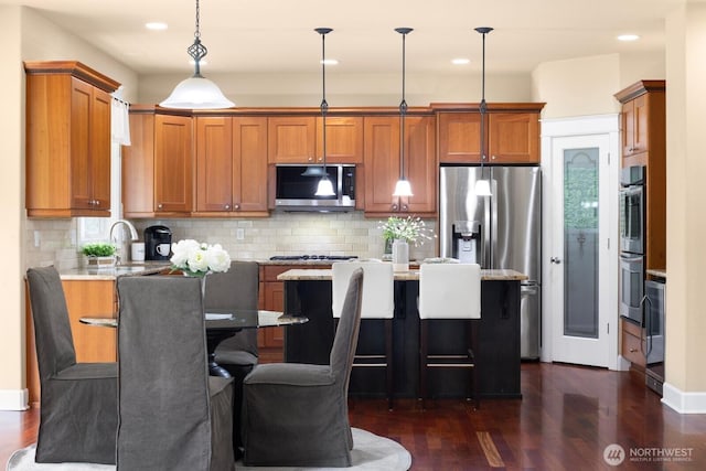 21515 26th St E, Lake Tapps, WA 98391 - kitchen with stainless steel appliances, dark wood-style floors, brown cabinetry, decorative backsplash, and recessed lighting