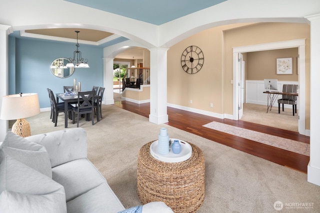 21515 26th St E, Lake Tapps, WA 98391 - living area with arched walkways, carpet, decorative columns, wood finished floors, and a chandelier