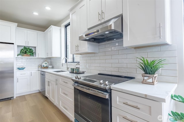 1019 Sturgus Ave S Unit A, Seattle, WA 98144 - kitchen with stainless steel appliances, under cabinet range hood, a sink, white cabinetry, and light wood-type flooring