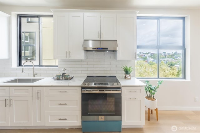 1019 Sturgus Ave S Unit A, Seattle, WA 98144 - kitchen featuring under cabinet range hood, stainless steel electric stove, a sink, backsplash, and white cabinetry