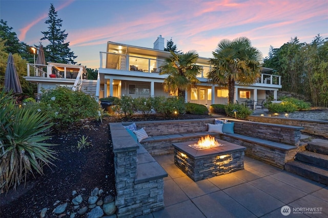 1505 E Horizon Dr, Mukilteo, WA 98275 - back of property at dusk featuring an outdoor fire pit, stairway, a balcony, a chimney, and a patio