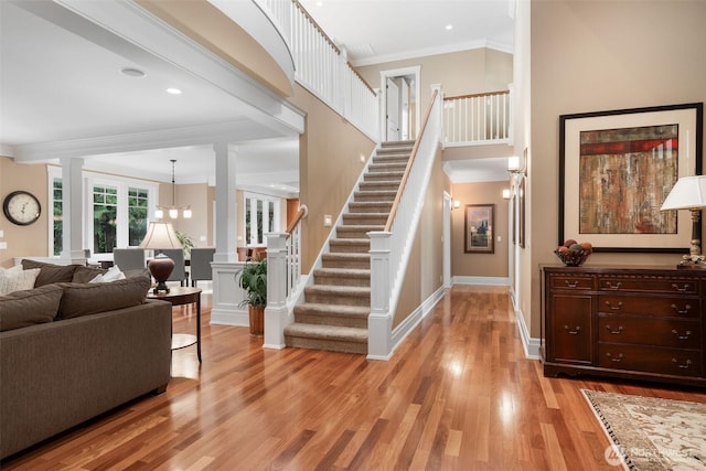 2920 39th Ln NW, Olympia, WA 98502 - living area featuring crown molding, light wood finished floors, a chandelier, stairs, and baseboards