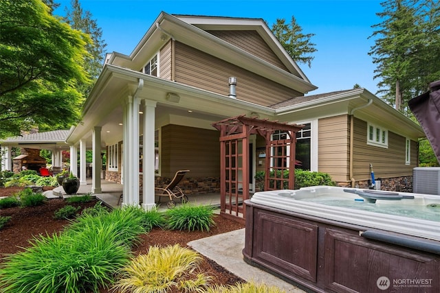 2920 39th Ln NW, Olympia, WA 98502 - rear view of house featuring a hot tub, central AC, and stone siding