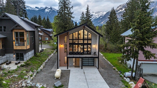 400 Hyak Dr E, Snoqualmie Pass, WA 98068 - back of property with a mountain view, an attached garage, driveway, and a balcony