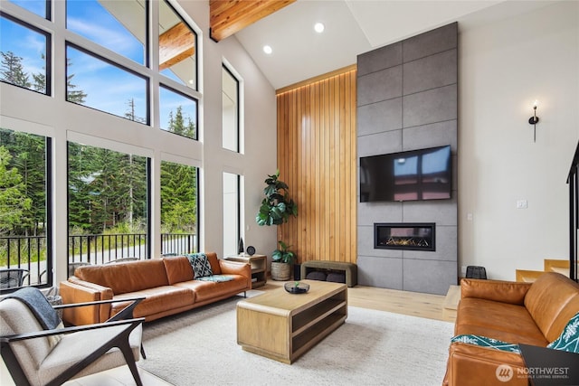400 Hyak Dr E, Snoqualmie Pass, WA 98068 - living room featuring high vaulted ceiling, a tiled fireplace, wood finished floors, beamed ceiling, and recessed lighting