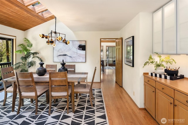 6160 W Mercer Way, Mercer Island, WA 98040 - dining space featuring a skylight, light wood finished floors, a chandelier, and vaulted ceiling