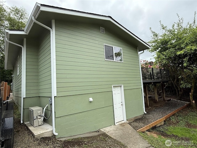 view of side of property featuring a deck and a cooling unit