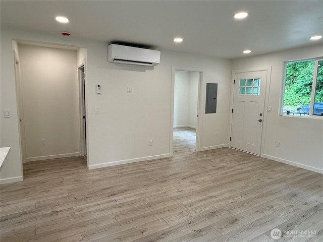 foyer entrance with a wall unit AC, electric panel, recessed lighting, light wood finished floors, and baseboards