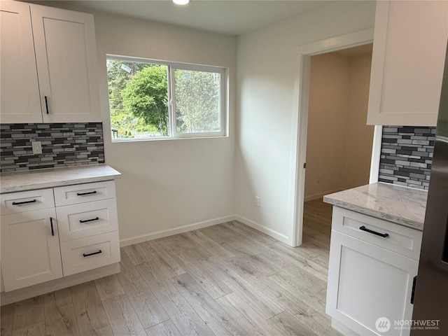 kitchen with backsplash, light wood-style floors, white cabinetry, and recessed lighting