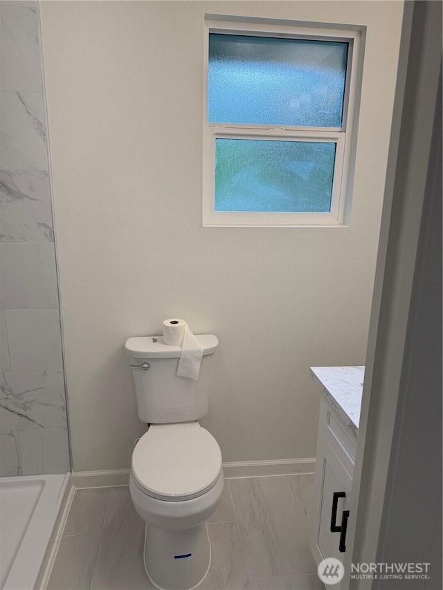 full bathroom featuring marble look tiles, baseboards, vanity, toilet, and a shower