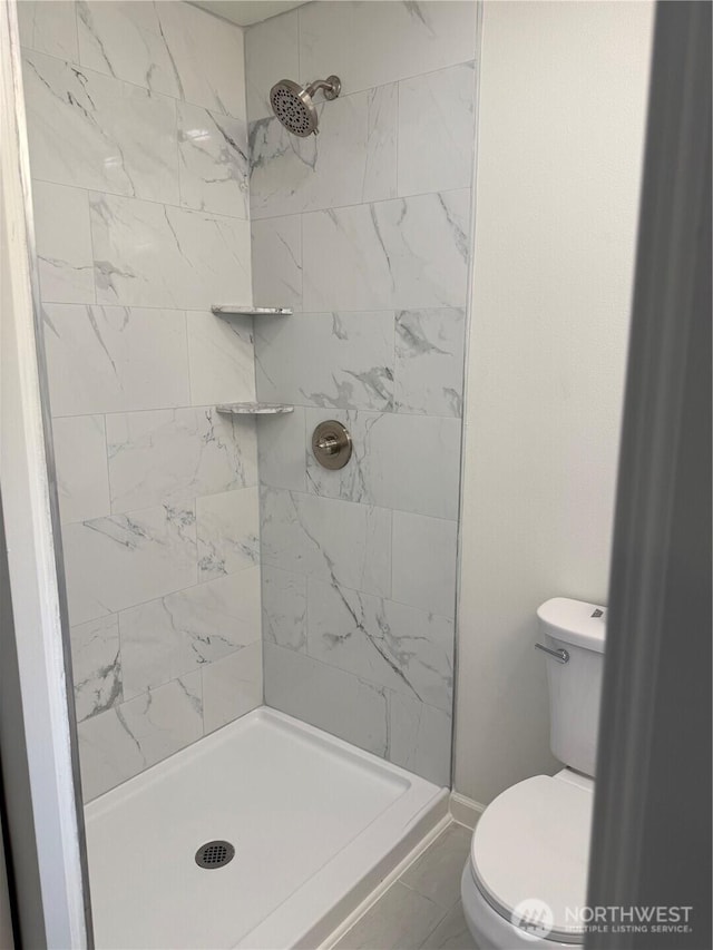 full bathroom featuring a stall shower and toilet