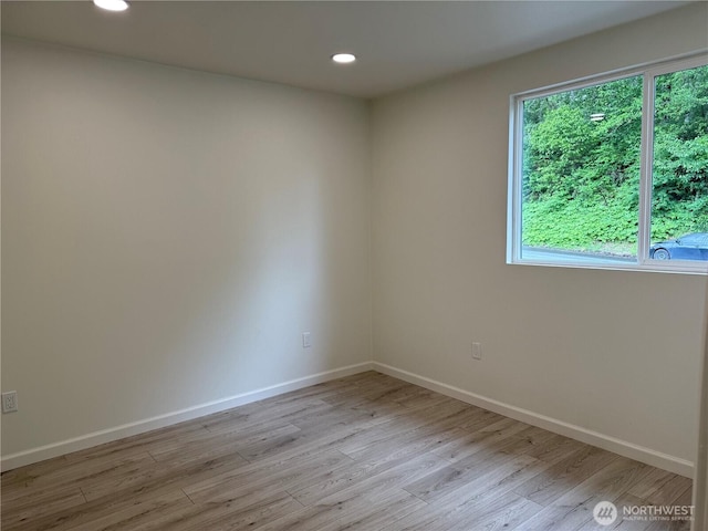 empty room featuring light wood-style floors, baseboards, and recessed lighting