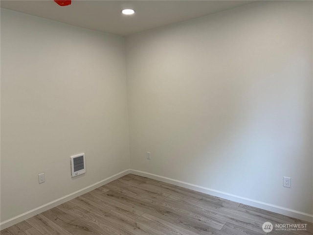 spare room with baseboards, light wood finished floors, and recessed lighting