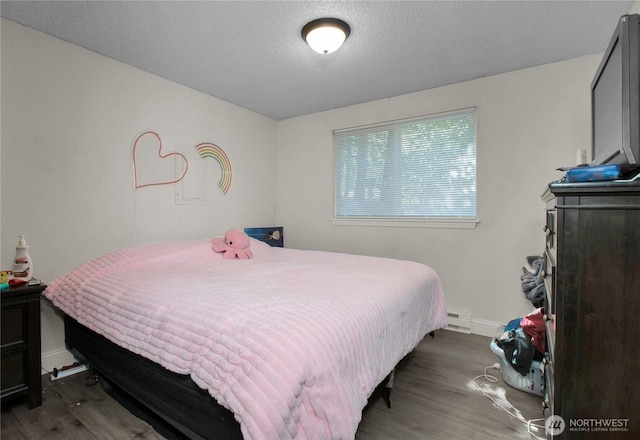 8024 N Bicentennial Loop SE, Lacey, WA 98503 - bedroom with wood finished floors, a baseboard radiator, baseboards, and a textured ceiling