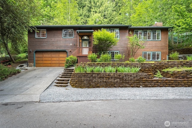 4 Alder Ct, Bellingham, WA 98229 - raised ranch with a chimney, an attached garage, driveway, and a view of trees
