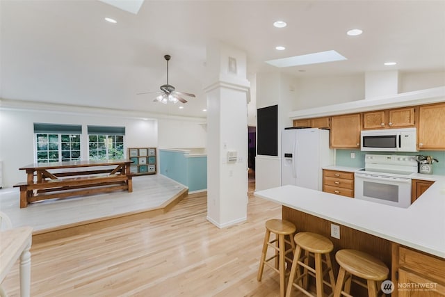 4 Alder Ct, Bellingham, WA 98229 - kitchen with white appliances, a skylight, light countertops, brown cabinetry, and light wood-style floors