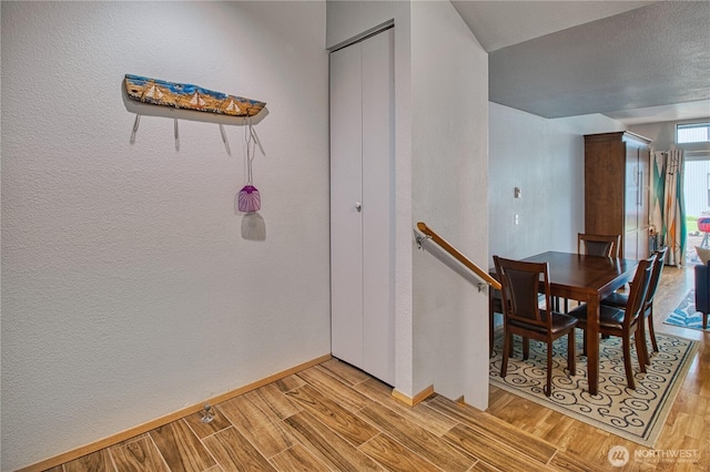 7806 Birch Bay Dr Unit 1007, Blaine, WA 98230 - dining space featuring light wood-type flooring, a textured wall, and baseboards