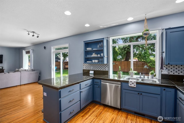176 Raspberry Ln, Woodland, WA 98674 - kitchen with dishwasher, blue cabinets, a sink, a peninsula, and tasteful backsplash