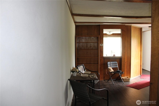 hall featuring a desk, wood finished floors, and beamed ceiling