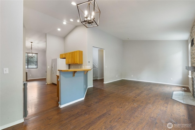 2538 Hidden Springs Loop SE, Olympia, WA 98503 - kitchen with a chandelier, white fridge with ice dispenser, light brown cabinets, a breakfast bar area, and baseboards