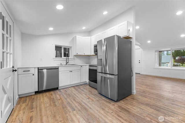 7409 Myers Rd, Bonney Lake, WA 98391 - kitchen with appliances with stainless steel finishes, light wood finished floors, white cabinets, light countertops, and recessed lighting