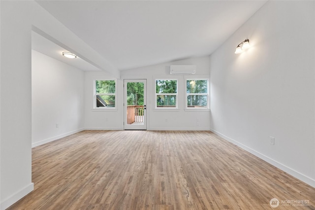 7409 Myers Rd, Bonney Lake, WA 98391 - unfurnished living room with light wood-style flooring, vaulted ceiling, and a wall mounted AC