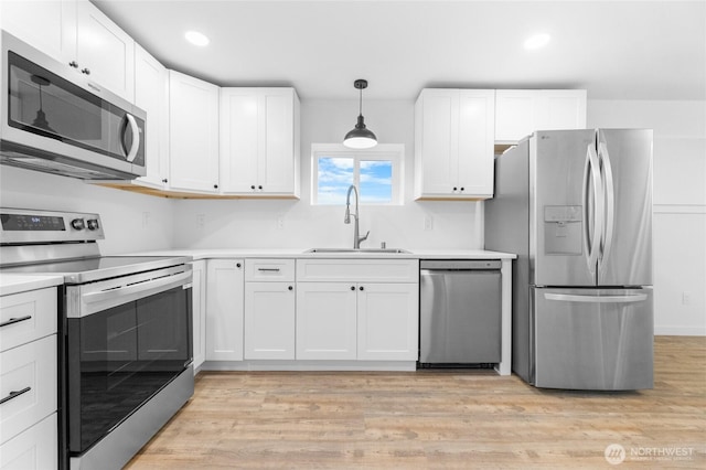 7409 Myers Rd, Bonney Lake, WA 98391 - kitchen featuring stainless steel appliances, light countertops, white cabinets, light wood-style floors, and recessed lighting