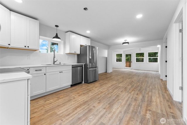 7409 Myers Rd, Bonney Lake, WA 98391 - kitchen featuring stainless steel appliances, light countertops, light wood-style flooring, white cabinetry, and recessed lighting