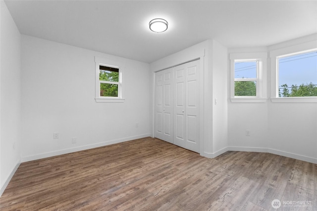 7409 Myers Rd, Bonney Lake, WA 98391 - unfurnished bedroom featuring multiple windows, wood finished floors, and a closet