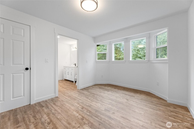 7409 Myers Rd, Bonney Lake, WA 98391 - unfurnished bedroom featuring light wood-type flooring, multiple windows, and ensuite bath