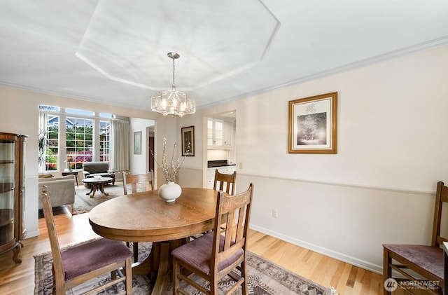 3238 NE 100th St Unit D, Seattle, WA 98125 - dining room featuring a chandelier, ornamental molding, light wood-type flooring, and baseboards