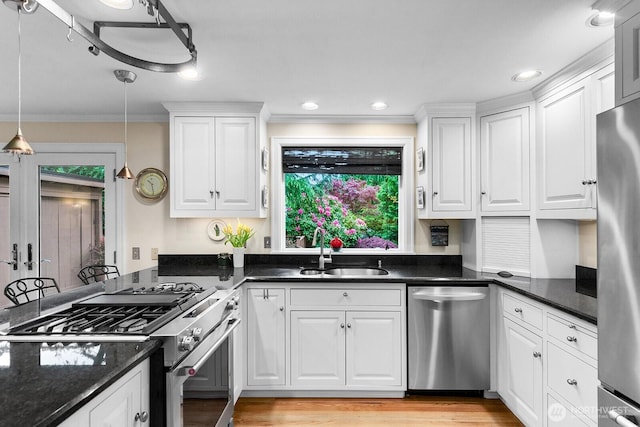 3238 NE 100th St Unit D, Seattle, WA 98125 - kitchen featuring stainless steel appliances, a sink, white cabinetry, crown molding, and light wood-type flooring