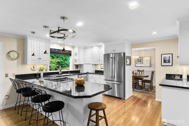 3238 NE 100th St Unit D, Seattle, WA 98125 - kitchen with stainless steel appliances, a peninsula, white cabinetry, dark countertops, and ornamental molding