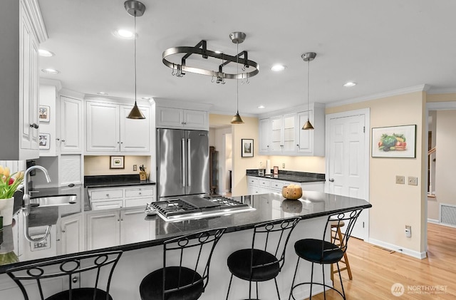 3238 NE 100th St Unit D, Seattle, WA 98125 - kitchen with appliances with stainless steel finishes, a sink, dark countertops, a breakfast bar area, and crown molding