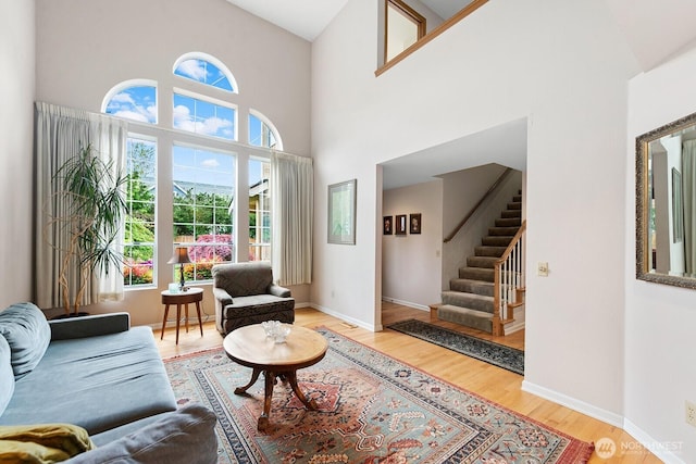 3238 NE 100th St Unit D, Seattle, WA 98125 - living area with wood finished floors, a towering ceiling, stairway, and baseboards