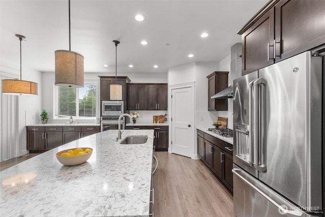 10815 NE 190th Pl, Bothell, WA 98011 - kitchen with appliances with stainless steel finishes, a sink, dark brown cabinetry, light wood-style flooring, and pendant lighting