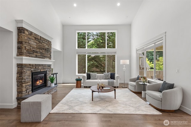 10815 NE 190th Pl, Bothell, WA 98011 - living room with a towering ceiling, a fireplace, wood finished floors, baseboards, and recessed lighting