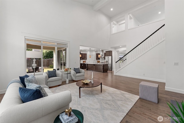 10815 NE 190th Pl, Bothell, WA 98011 - living area featuring wood finished floors, stairway, a towering ceiling, beam ceiling, and baseboards