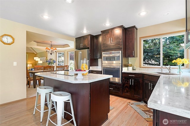 13218 42nd Ave W, Mukilteo, WA 98275 - kitchen featuring a sink, appliances with stainless steel finishes, a breakfast bar area, light wood-style floors, and recessed lighting