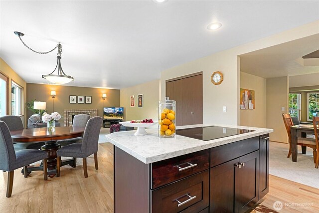 13218 42nd Ave W, Mukilteo, WA 98275 - kitchen featuring black electric stovetop, light wood-type flooring, open floor plan, a kitchen island, and dark brown cabinetry