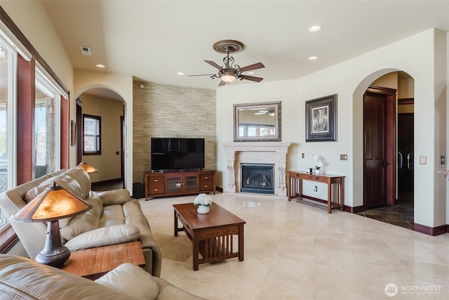 1844 Vineyard Pl, Bellingham, WA 98226 - living area with a ceiling fan, arched walkways, recessed lighting, a glass covered fireplace, and baseboards