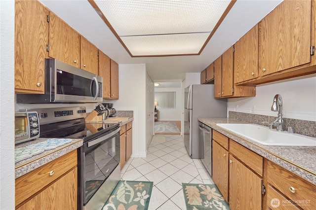 3135 Rustlewood Ln SE, Port Orchard, WA 98366 - kitchen featuring stainless steel appliances, a sink, light tile patterned flooring, light countertops, and brown cabinetry