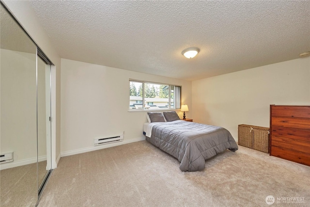 3135 Rustlewood Ln SE, Port Orchard, WA 98366 - carpeted bedroom featuring a baseboard radiator, a closet, a textured ceiling, and baseboards