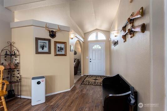 30350 Deer Meadows Rd E, Deer Meadows, WA 99122 - foyer entrance featuring dark wood-style flooring, arched walkways, lofted ceiling, and baseboards