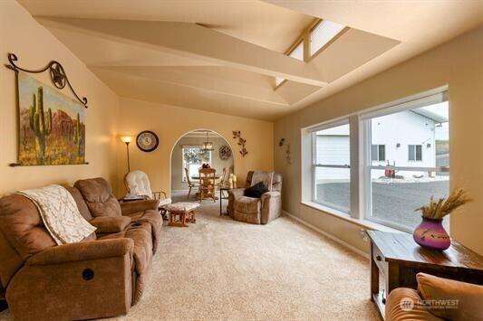 30350 Deer Meadows Rd E, Deer Meadows, WA 99122 - carpeted living room with arched walkways, healthy amount of natural light, and lofted ceiling
