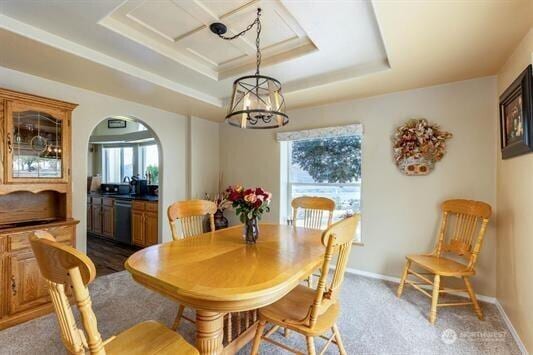 30350 Deer Meadows Rd E, Deer Meadows, WA 99122 - dining space featuring a tray ceiling, arched walkways, a chandelier, and baseboards